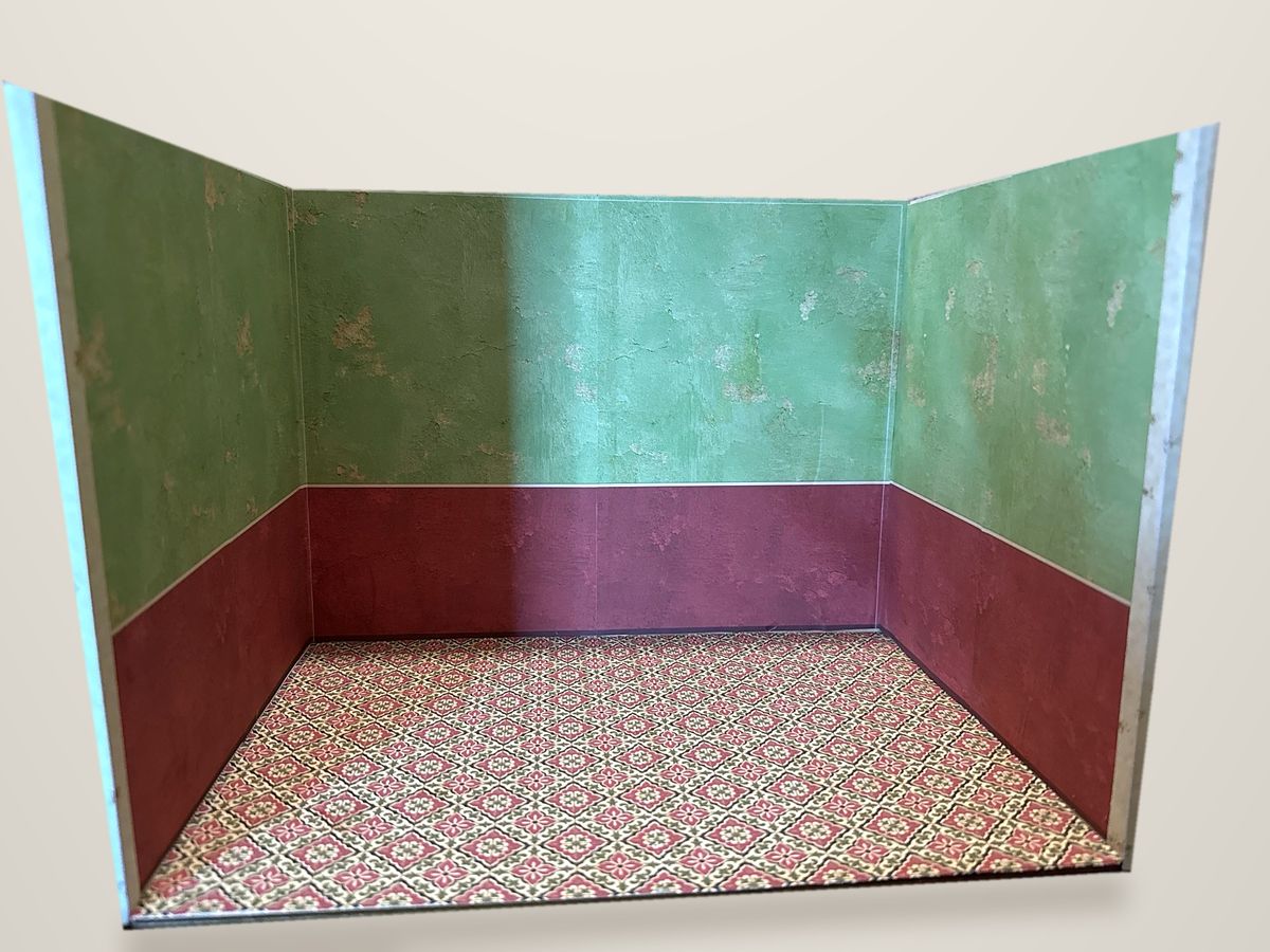 Empty room box with green upper walls, red lower walls and a red and green patterned tile floor