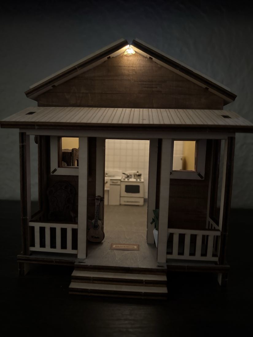 The casita at night, lit from inside, with the kitchen visible through the front door